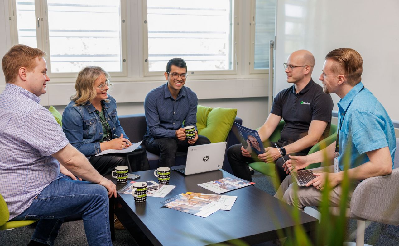9Solutions staff sitting and smiling around a table