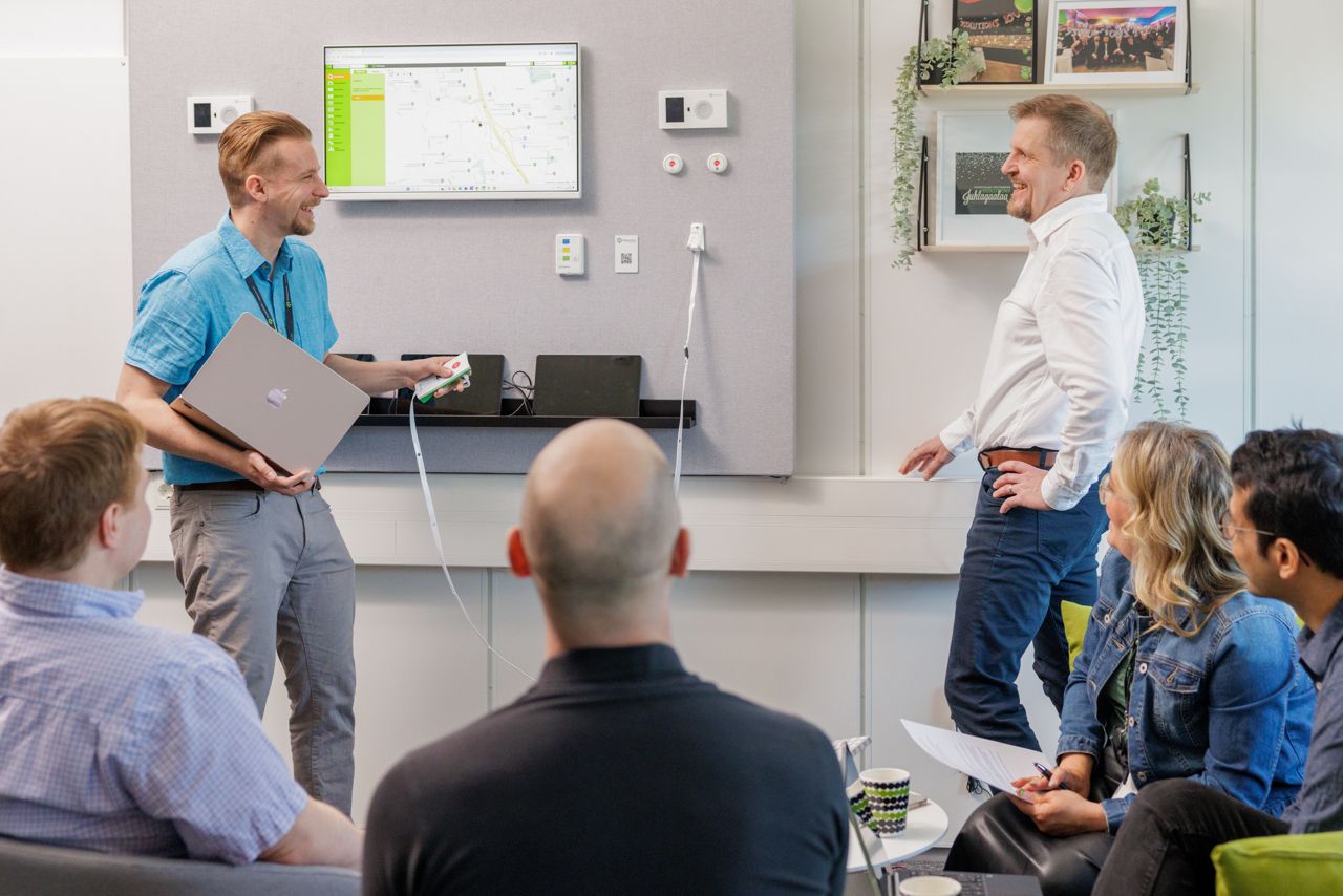 9Solutions employees showing nurse call device to eachother