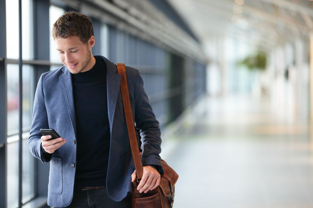 Man looking at black mobile phone