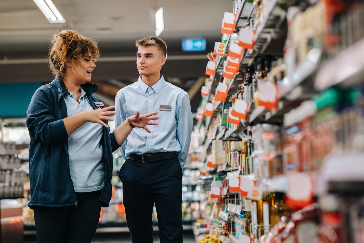 Two retail employees talking in a supermarket