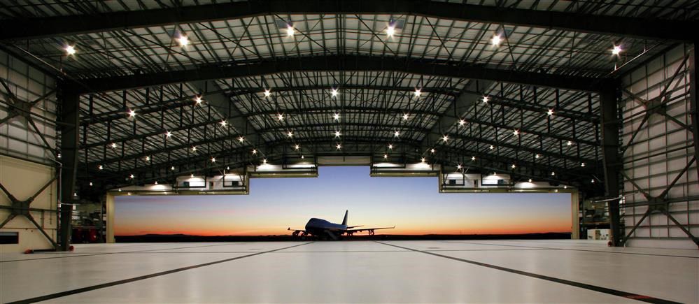 Hangar hall with airplain and sunset in the backround