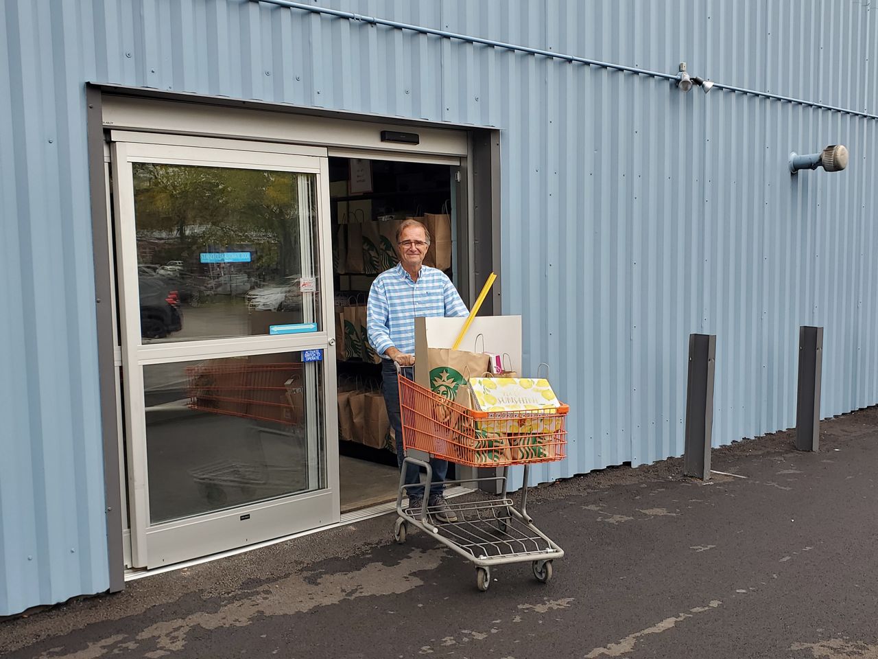 A man pushes a cart of donated school supplies through automatic doors