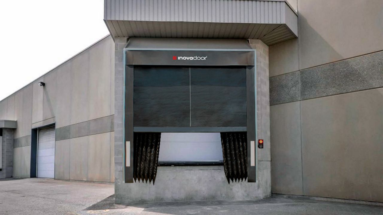 Image: Abrigo de Doca Inovadoor 203, com sistema de selamento inflável e cortinas internas flexíveis, instalado em doca de carregamento de centro logístico para proporcionar vedação superior entre o veículo e a edificação