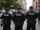 Three police officers standing on city street
