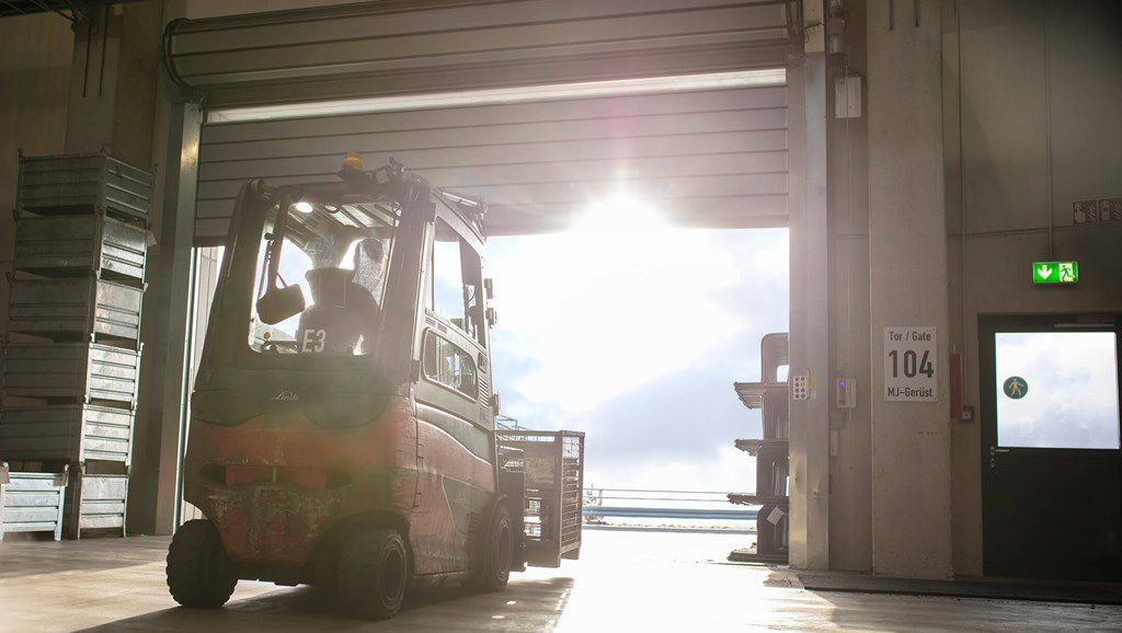A forklift from behind about to exit through high-speed doors.