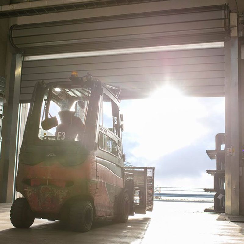 En gaffeltruck bakifrån är på väg att ta sig ut genom snabbrullportar.