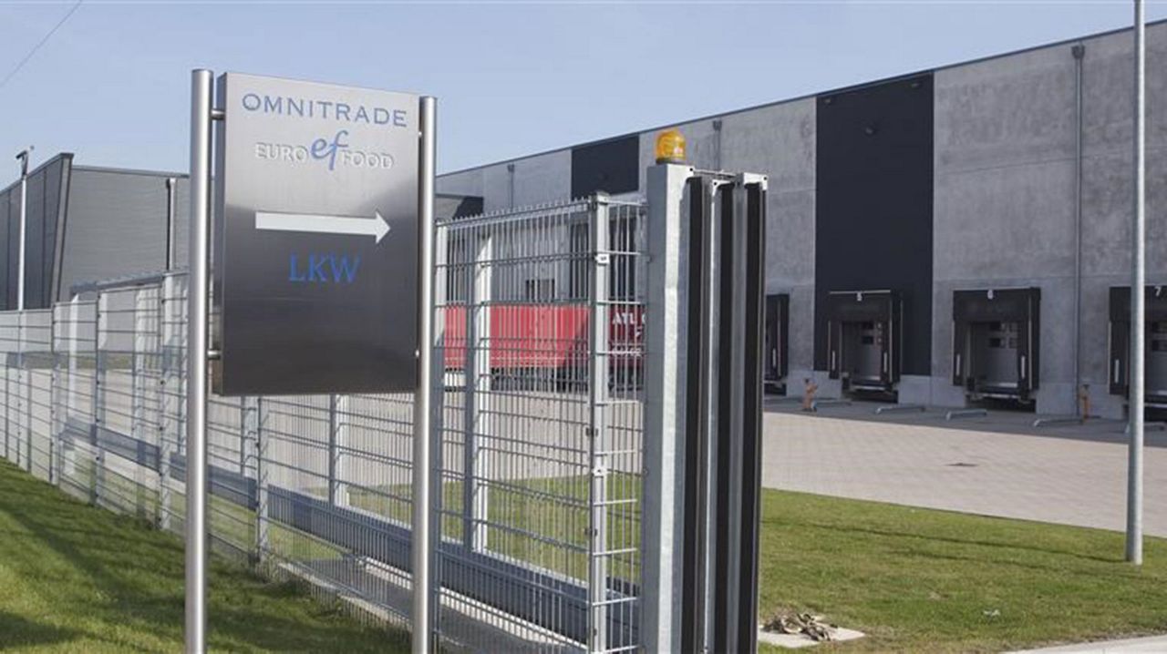 Omnitrade entrance sign by gate.  In the forground you can see the distribution centre and docking. 