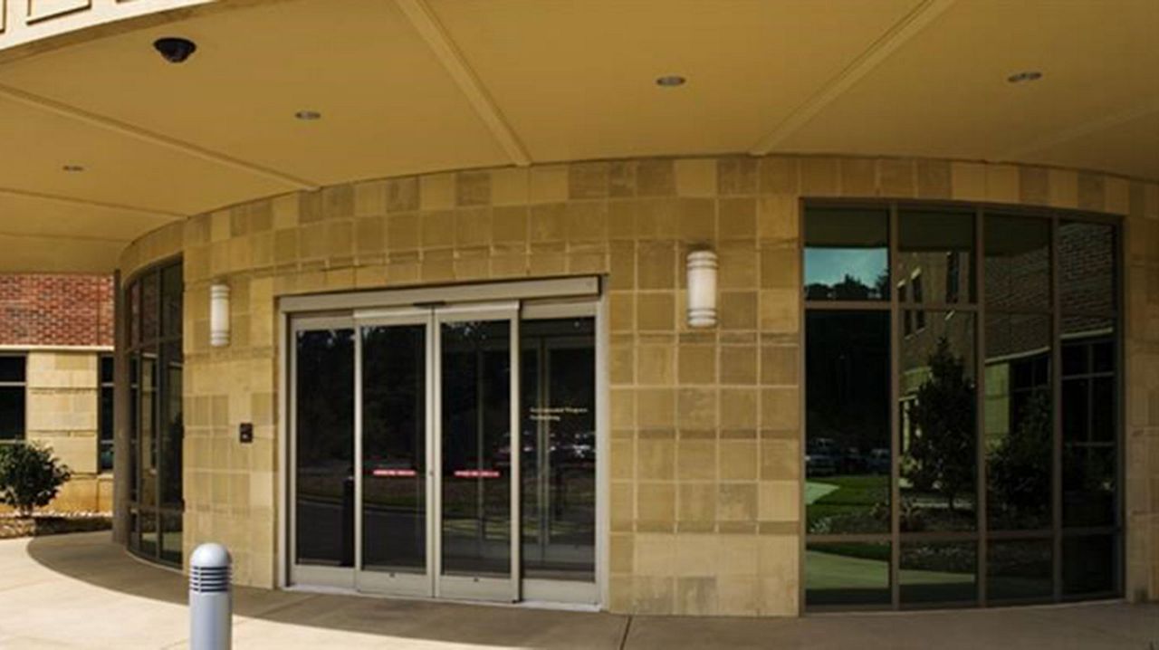 Portas de correr da entrada do The Rosedale Medical Center. Um edifício em tijolo amarelo com portas de correr automáticas em vidro. 