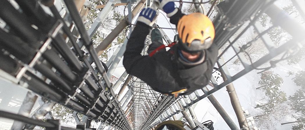 worker climbing telecom tower 