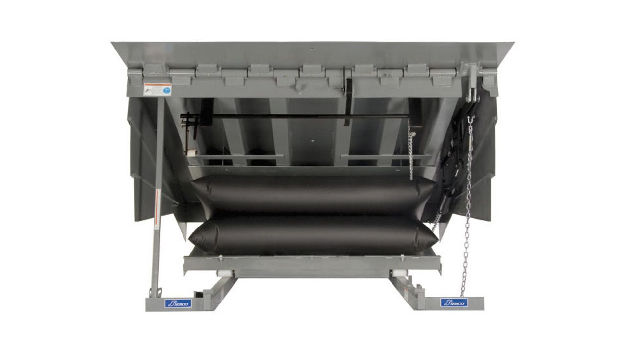 A silver dock leveler with black mechanisms.