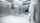 Hospital staff dressed in protection clothes and mask walking towards an open clean room door in a hospital.