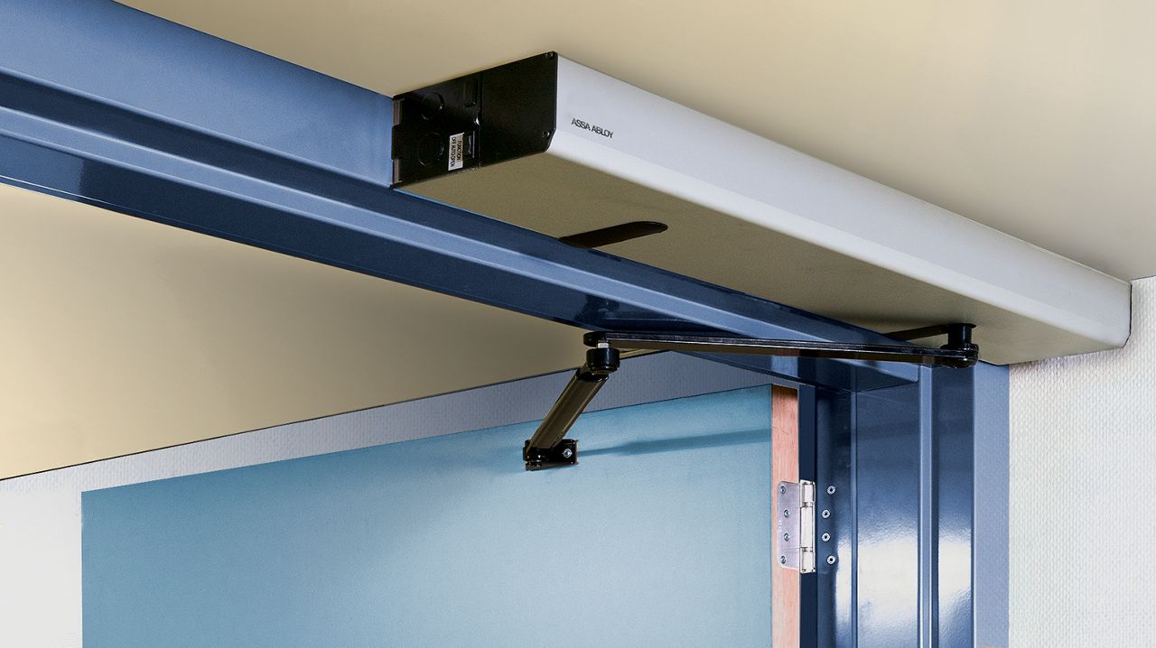 Primer plano del mecanismo para puertas batientes ASSA ABLOY SW100 en un hospital.
