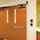 Orange doors with the ASSA ABLOY SW200i swing door operator in a hospital.