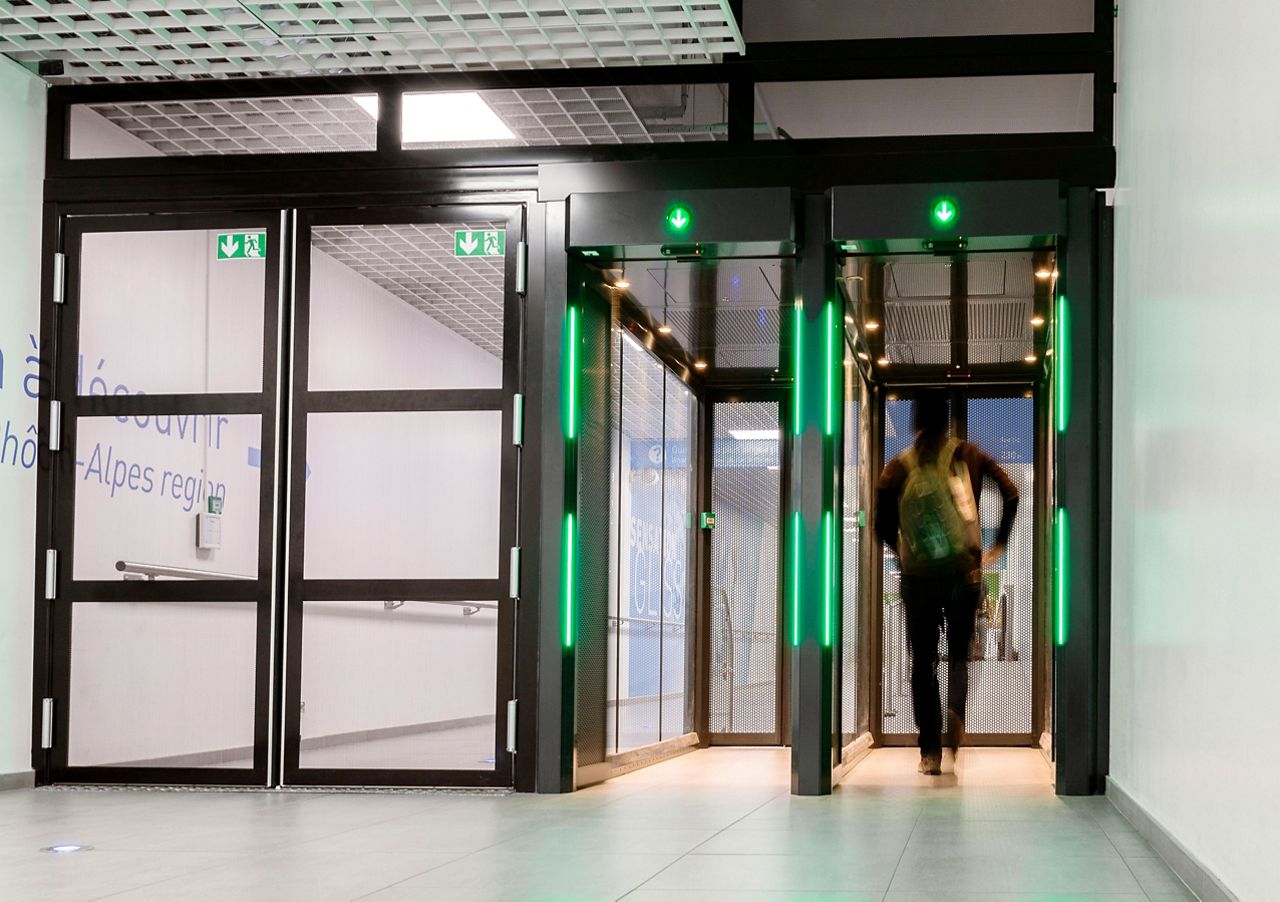 Person walking through secure exit lane breach control door