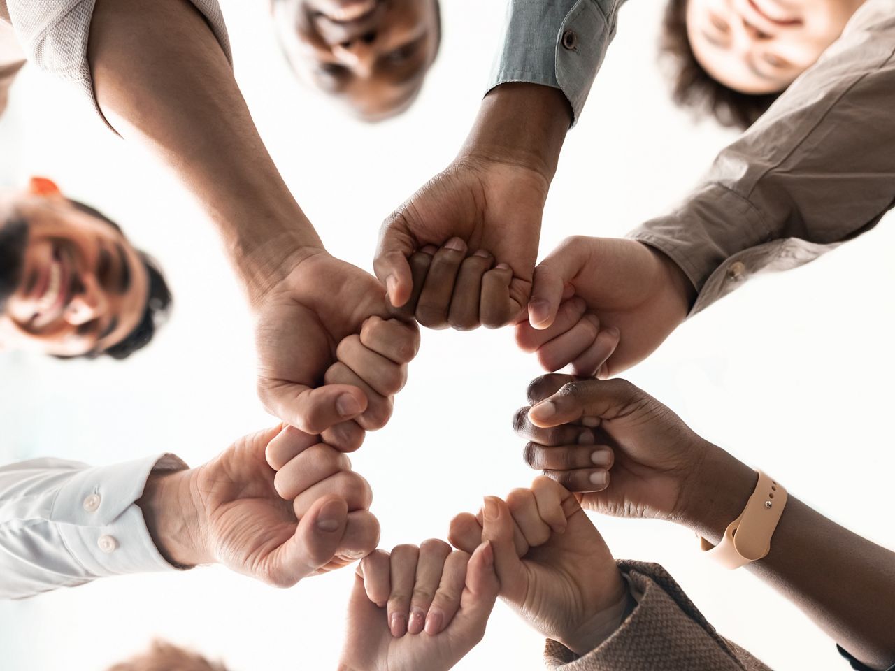 group of employees in a circle fist bumping