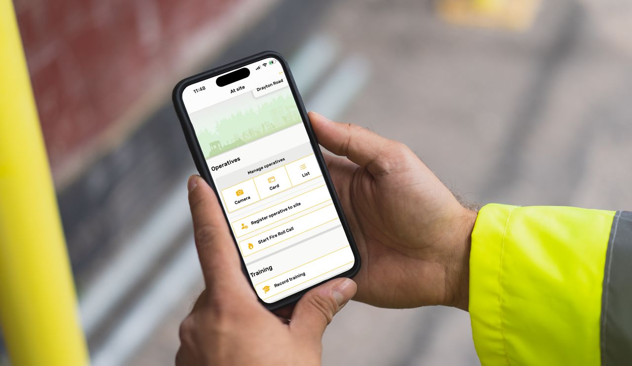 A person holds a mobile phone in their hands with workforce management software displayed