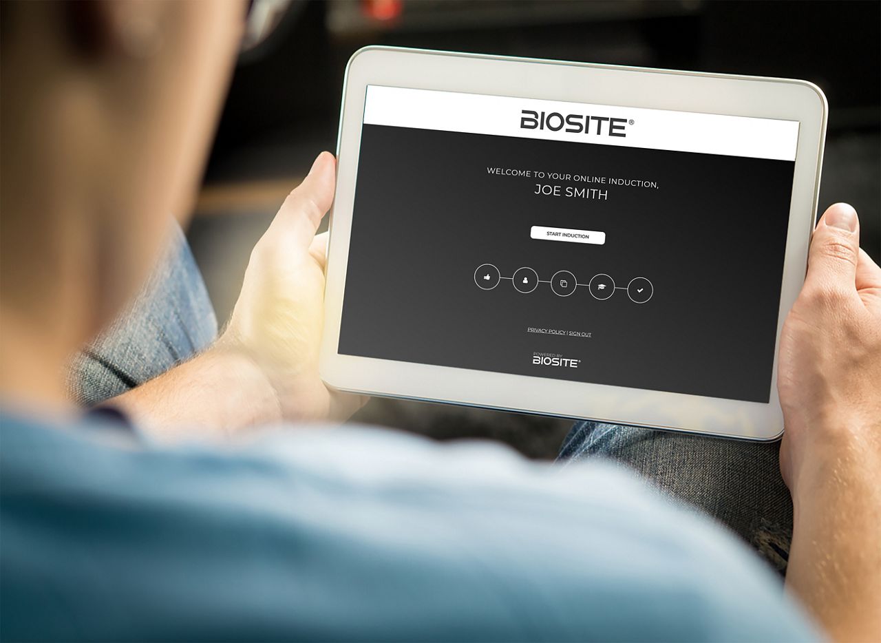 Person holiding a tablet device with Online Induction software
