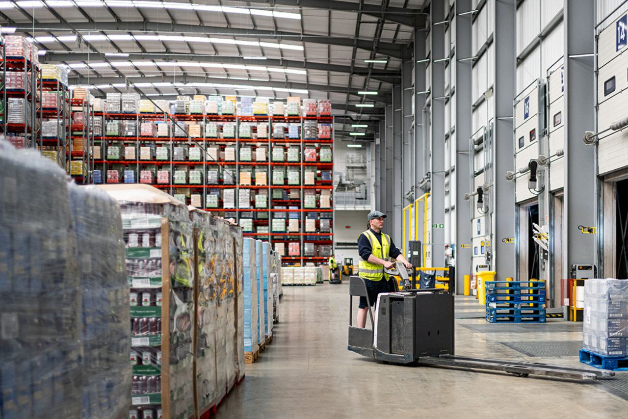 Logistics warehouse loading operations with worker transporting pallets