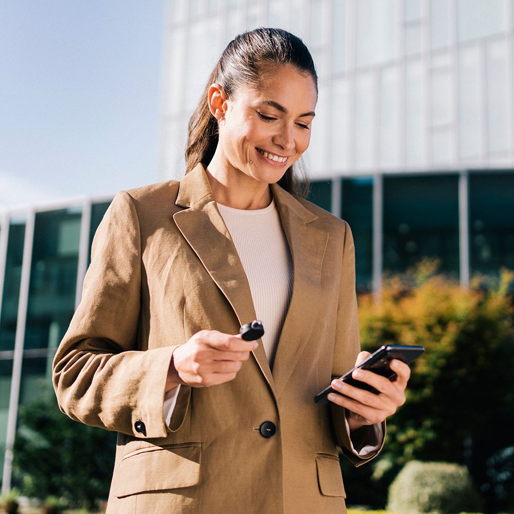 femeie ține în mână o cheie cliq și un smartphone