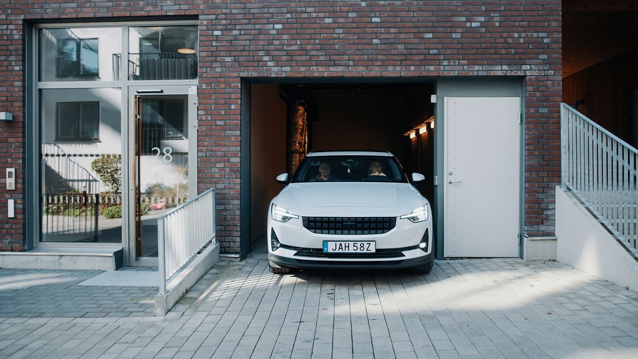 White car emerging from a garage in a residential apartment building