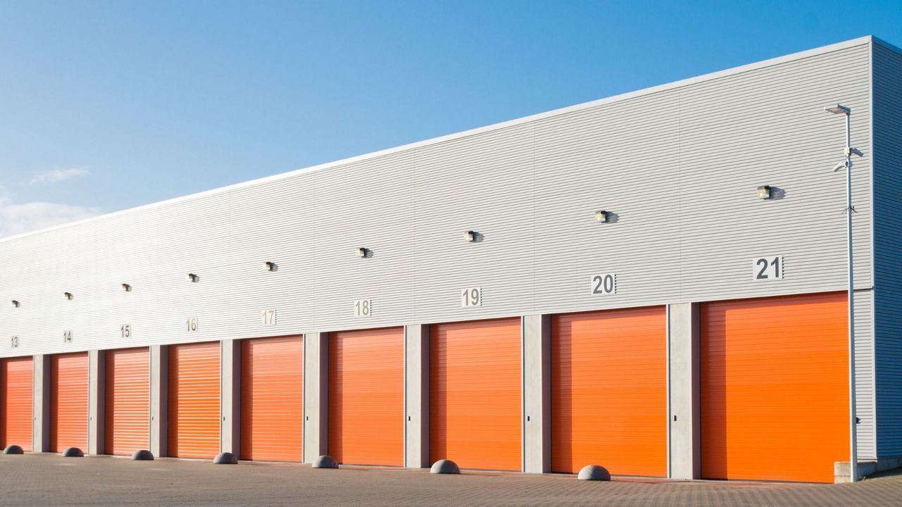 Batiment industriel avec portes sectionnelles oranges numérotées.