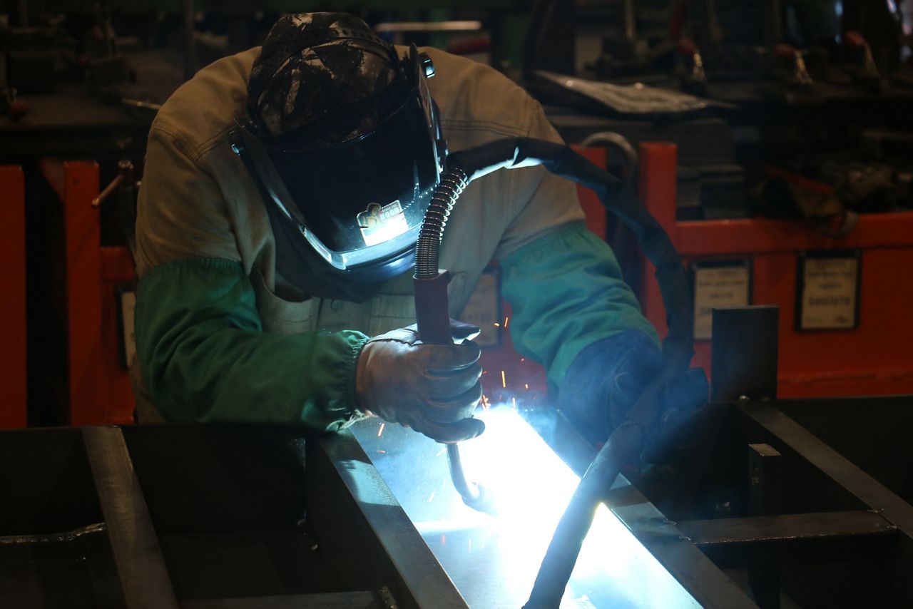 A welder in protective gear fusing metals together.
