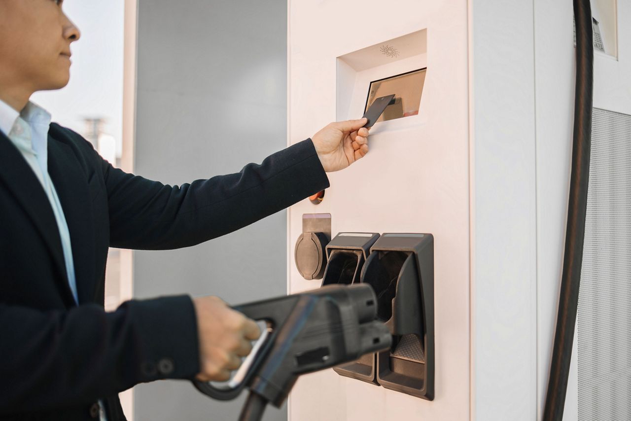 Man using card at EV charging station