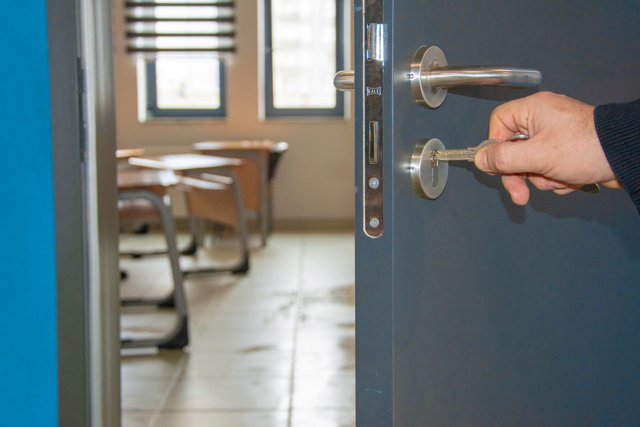 Man opening classroom door with key