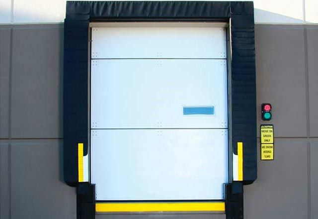 A white cold storage door outside of a warehouse