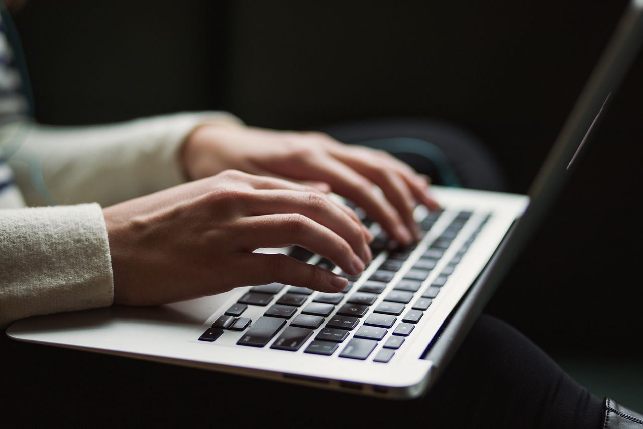 Femme tapant sur le clavier d'un ordinateur portable