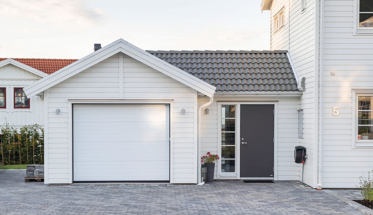 Denna takskjutport från Crawford är installerad i ett modernt hem där den stilrena designen smälter in i husets arkitektur. Ett exempel på hur form och funktion kan gå hand i hand i en genomtänkt helhetslösning.