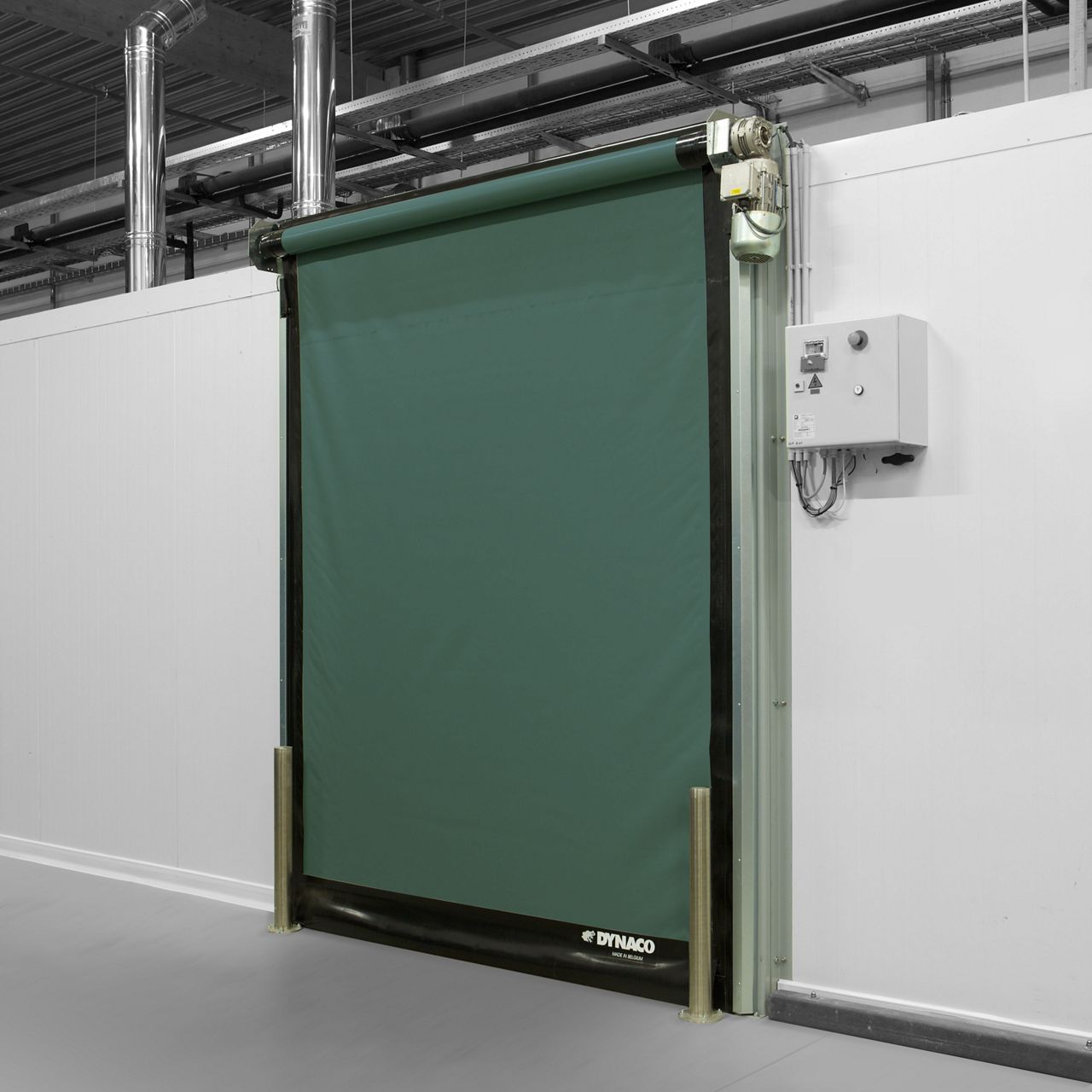 Un pasillo gris con puertas de alta velocidad de color verde oscuro.