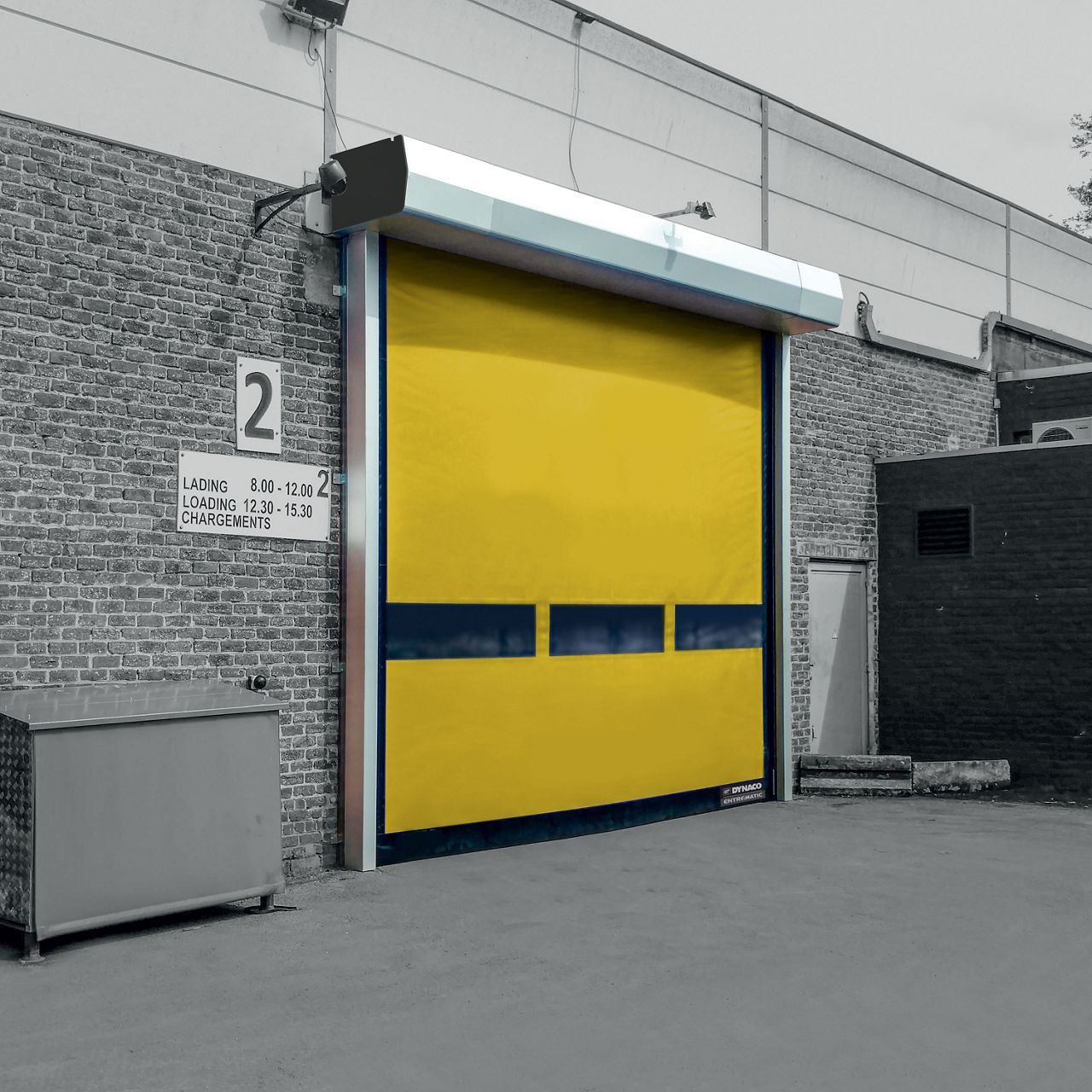 A yellow door installed on a grey building.