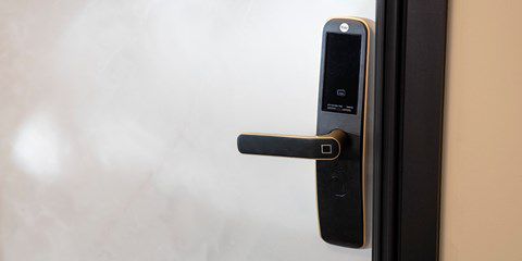Bílé dveře s černou dveřní klikou s integrovaným digitálním zámkem