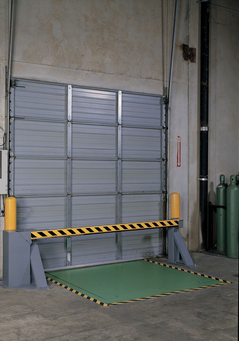 A black and yellow painted metal rectangular gate that is supported by a gray base