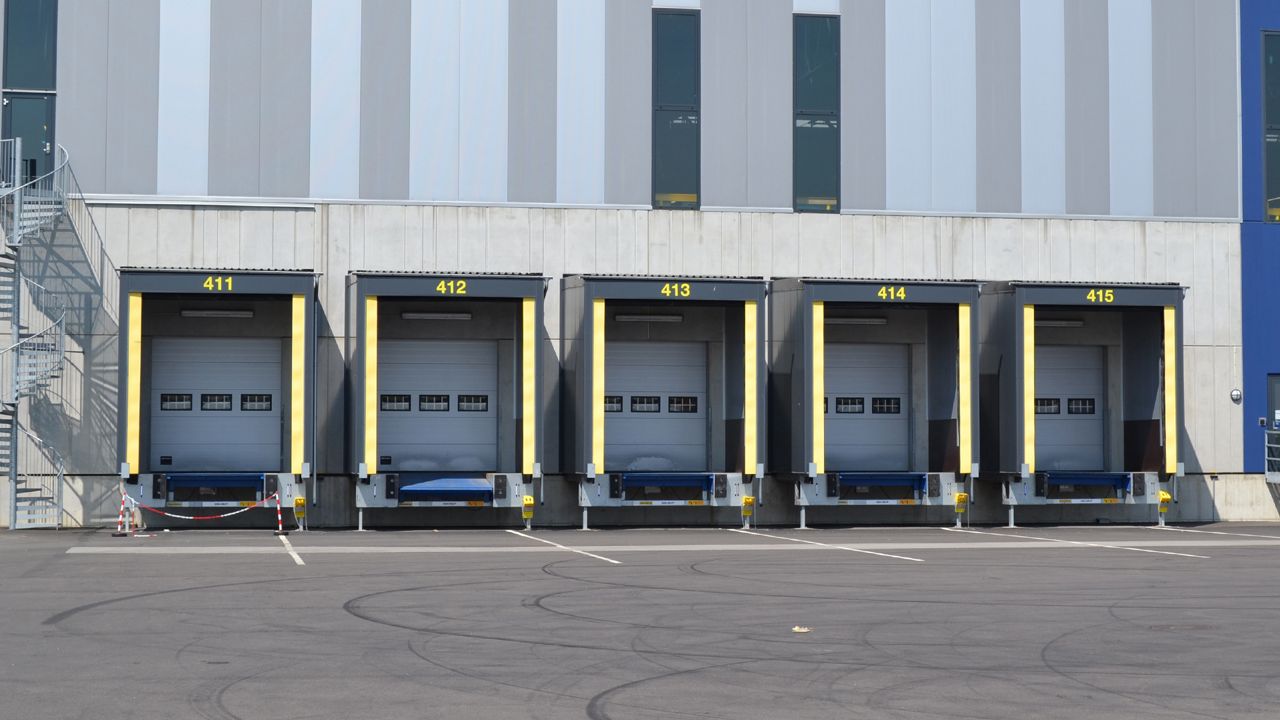 Image: Abrigo de Doca Inovadoor 203, com sistema de selamento inflável instalado em múltiplas docas de carregamento de centro logístico