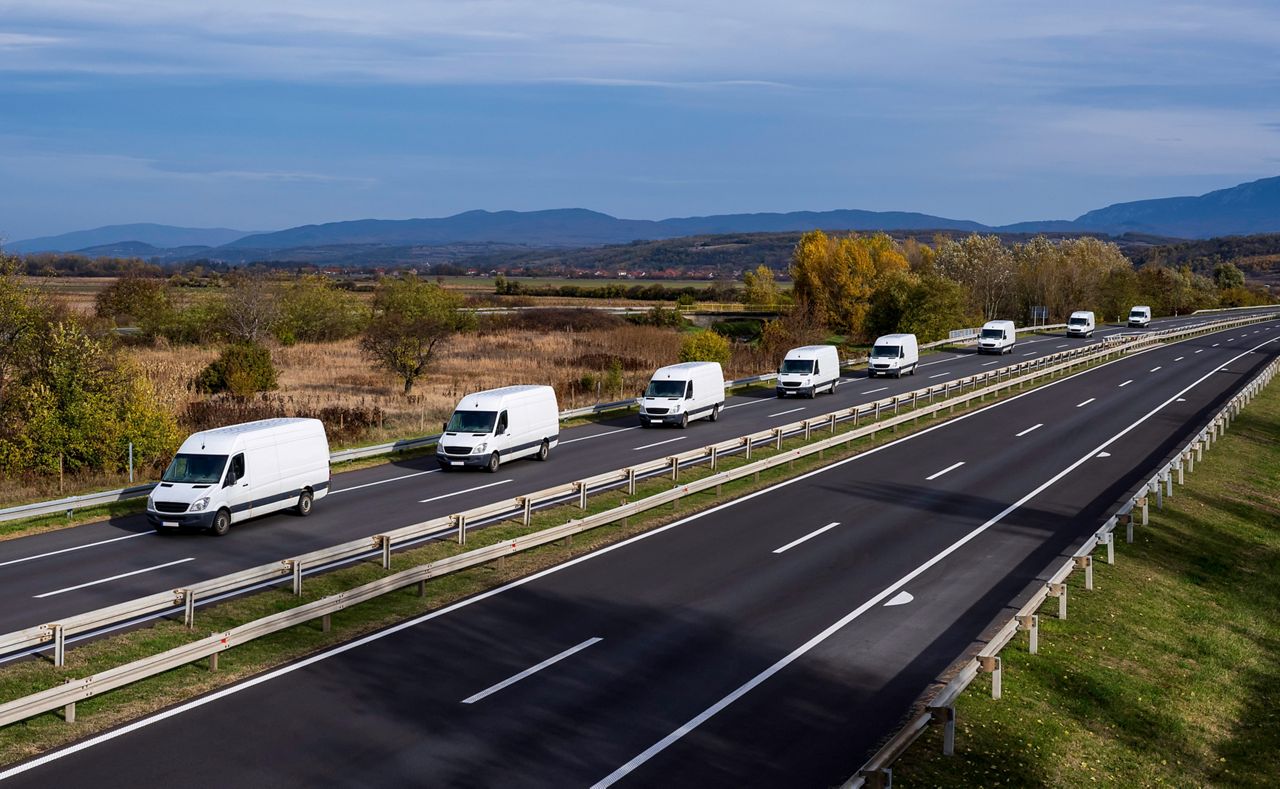Row of delivery vans on highway