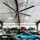 A black fan hanging above vintage cars in a garage