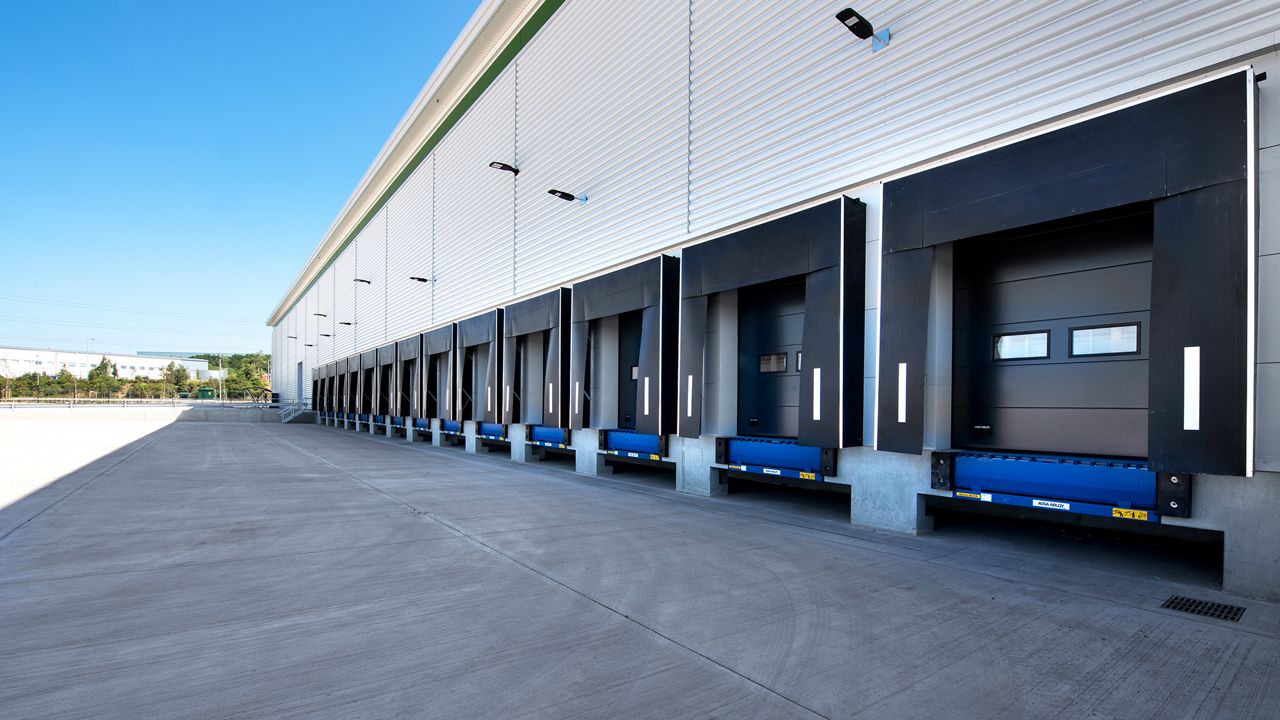 Docas de carregamento alinhadas na lateral de um centro de distribuição ou armazém logístico.