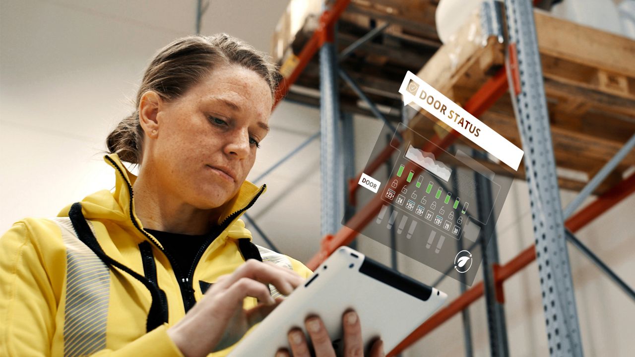 Terminalmedewerker bekijkt met behulp van een witte tablet de deurstatus in het Docking Management Systeem