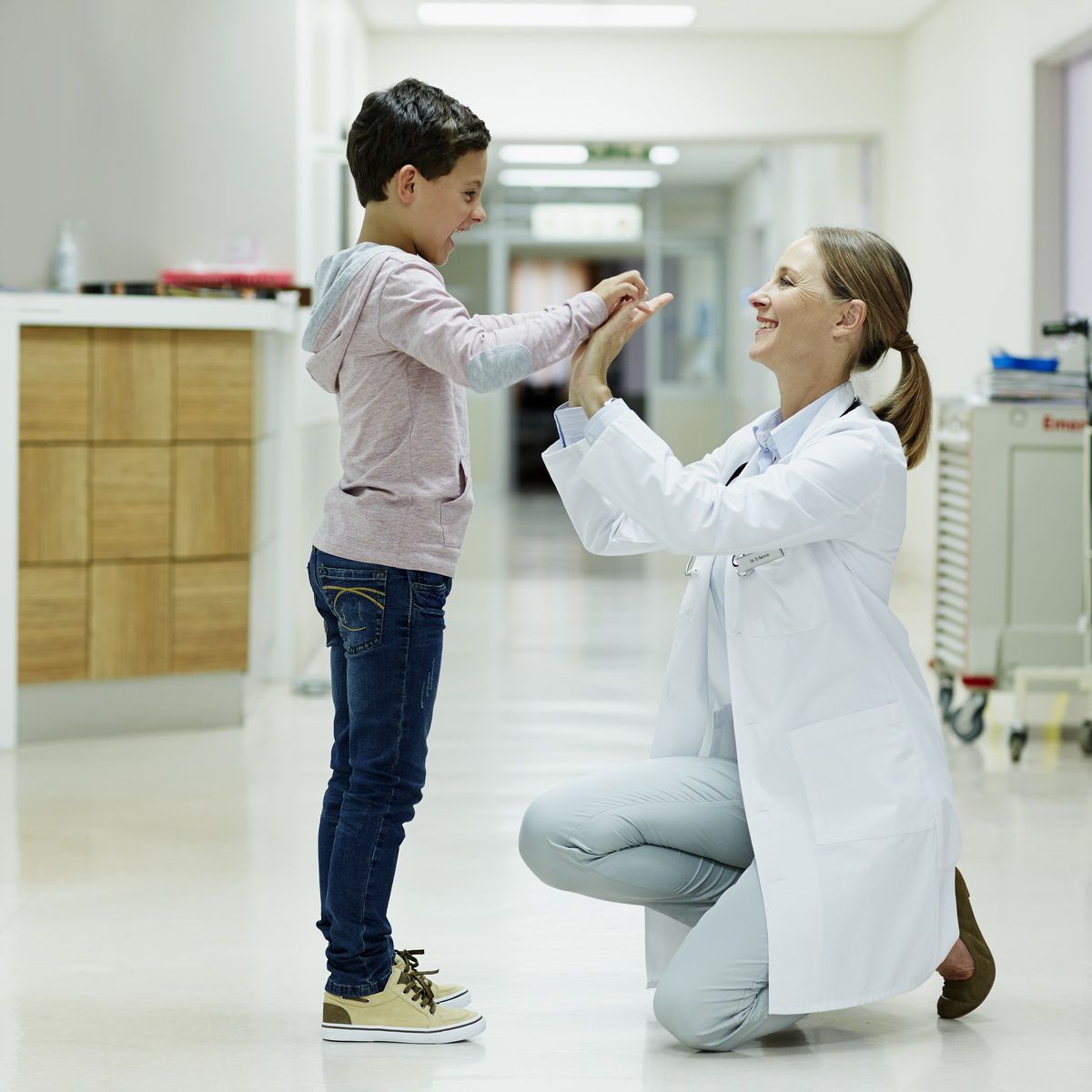 Doktor ger high five till en liten pojke.
