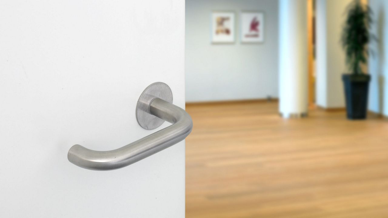 Et dørgreb fra ASSA ABLOY på en hvid dør