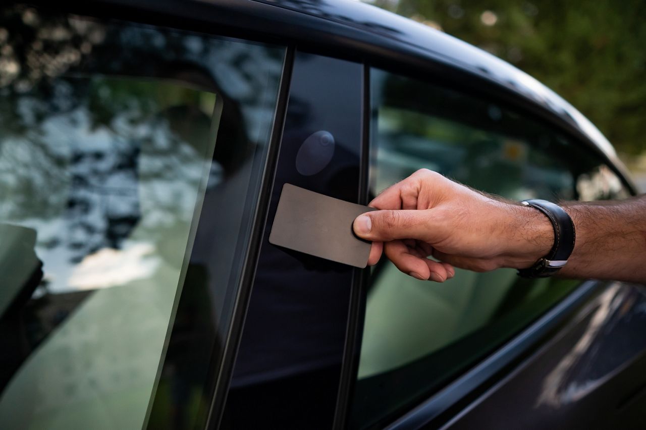 Man opens door on electric vehicle with card