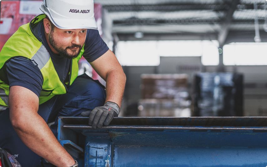 ASSA ABLOY employee working on a dockingsolution with a yellow vest and white helmet