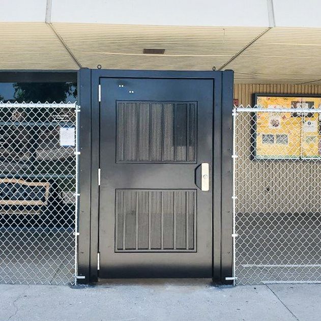 Exodus single swing gate with pickets, installed with chain link.