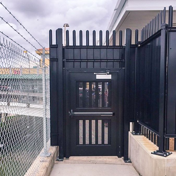 Exodus single swing gate with pales and panic hardware.