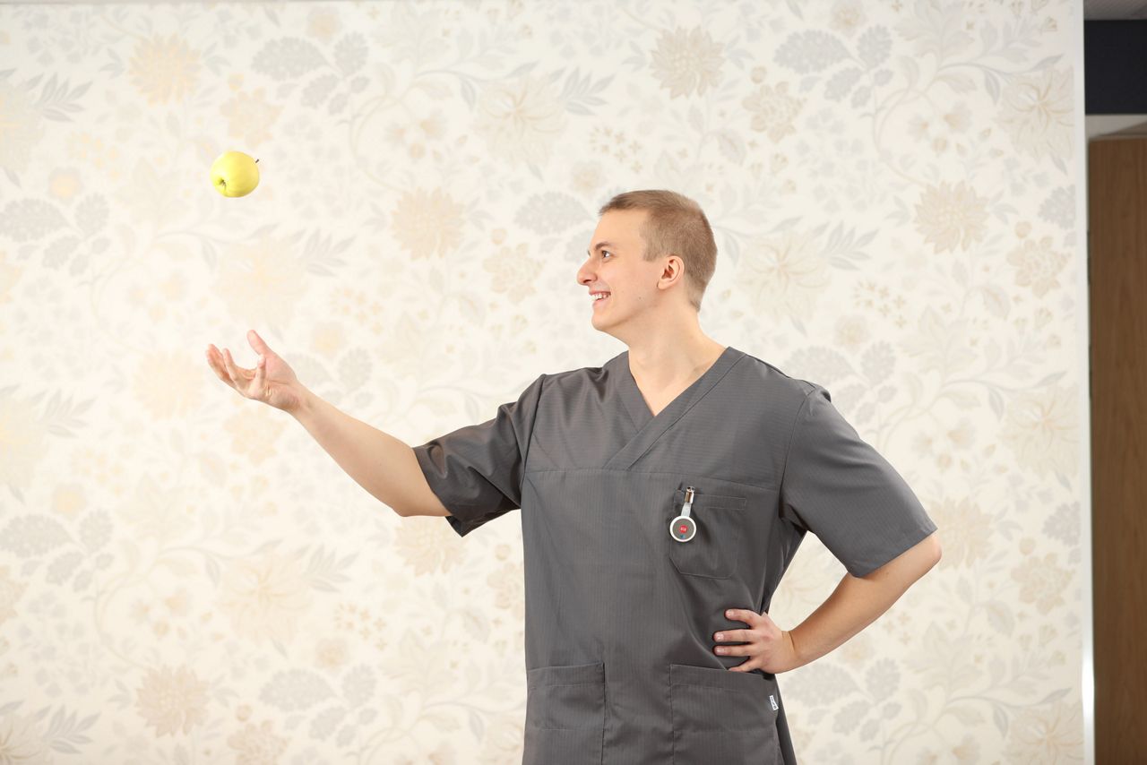 Male nurse standing and smiling wearing a 9solutions safety tag