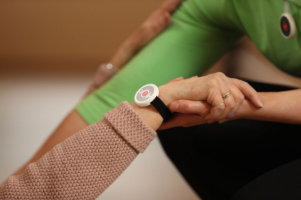 Nurse holding a fallen down old persons hand and lifting her up