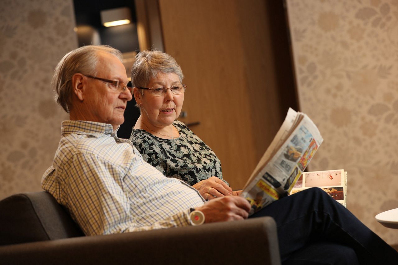 Two old people reading a newspaper