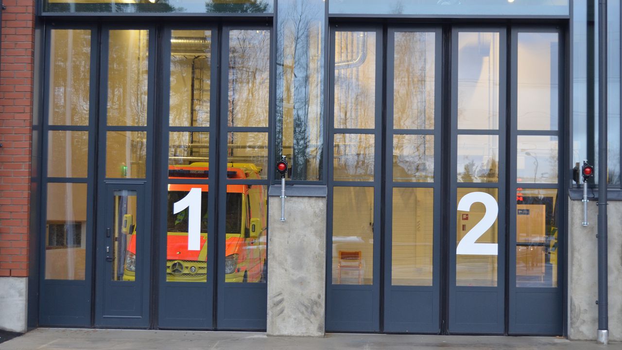 Two big glass doors with numbers on them, and on the right one you can see an ambulance inside. 